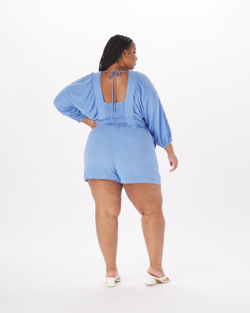 Back of a model wearing a size 4X Anna Peasant Romper in Periwinkle in Cornflower Blue by What Lo Wants. | dia_product_style_image_id:237980